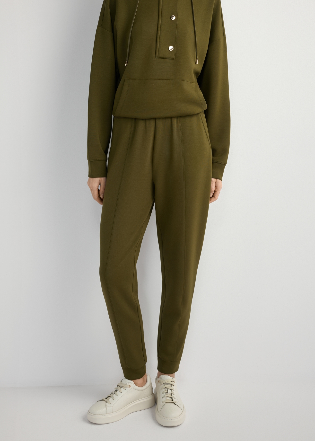 Spodnie damskie w kolorze khaki SPODT-0108-8D(W26), widok produktu z przodu na modelce. Widoczna połowa sylwetki.