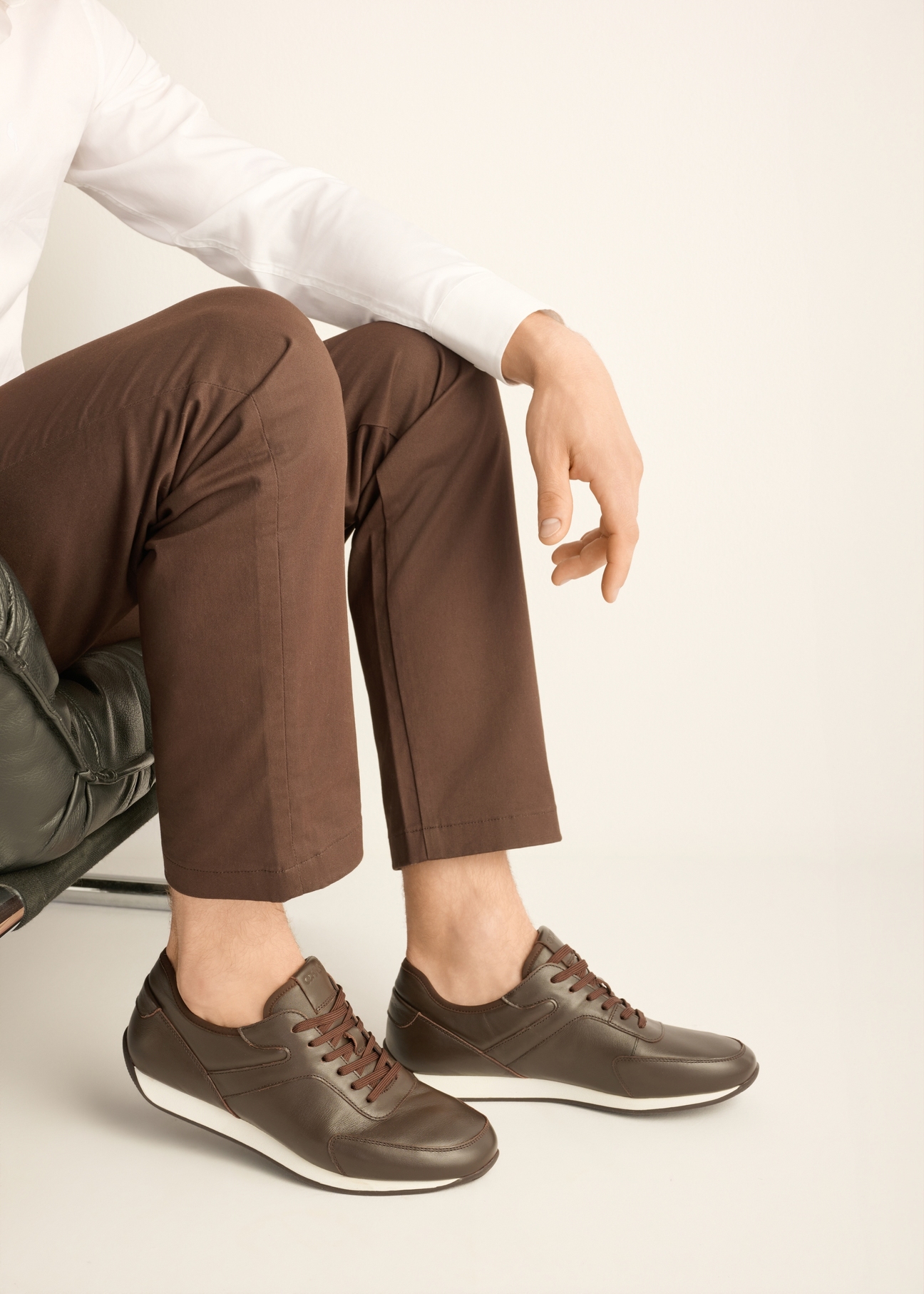 Brązowe skórzane buty sportowe męskie BUTYM-0566-1I(Z26) - widok produktu z z boku, na stopach modela, na jasnym tle. 