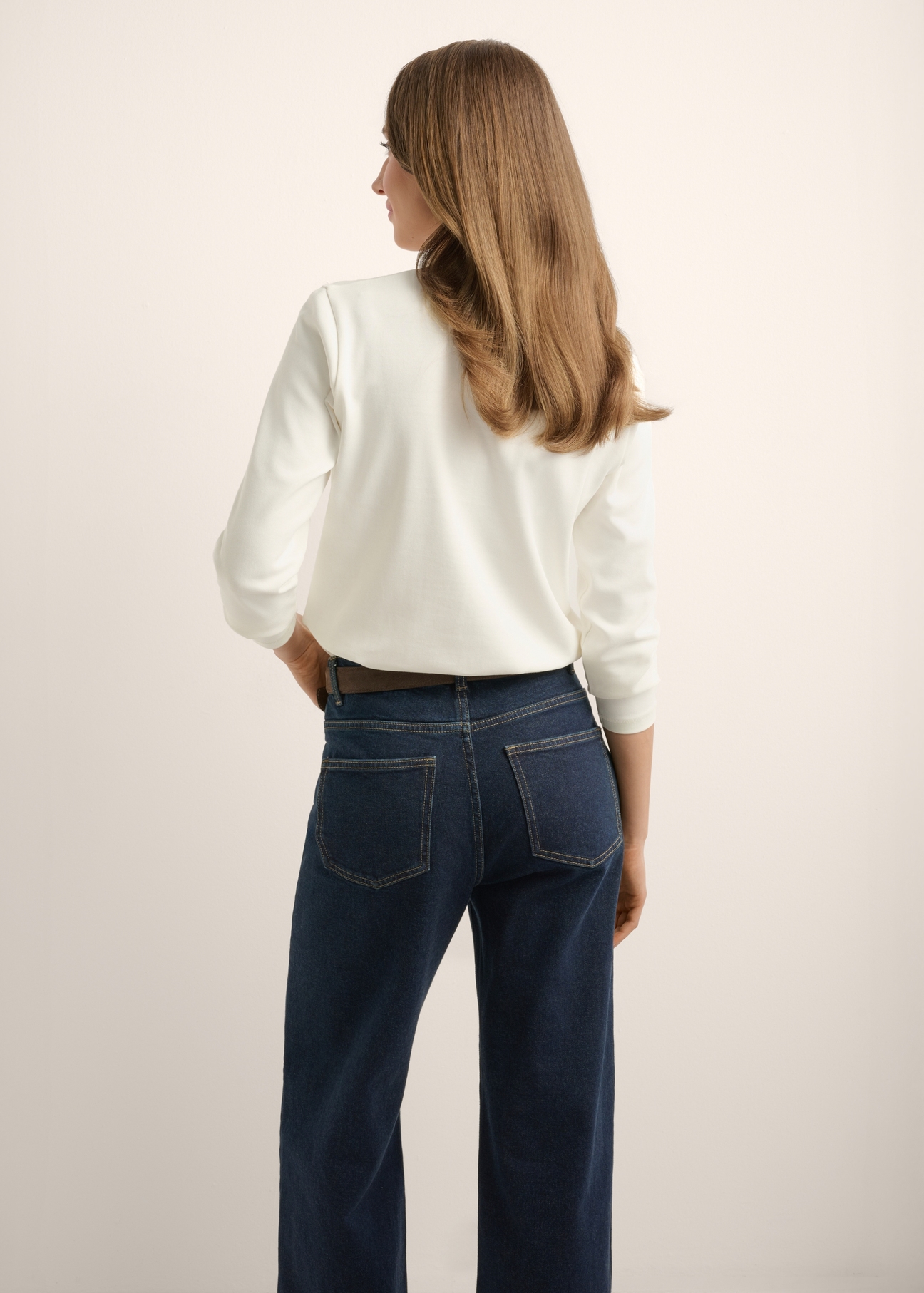 Kremowy bawełniany longsleeve damski LSLDT-0052-0B(Z26), widok produktu z tyłu na modelce. Widoczna połowa sylwetki.