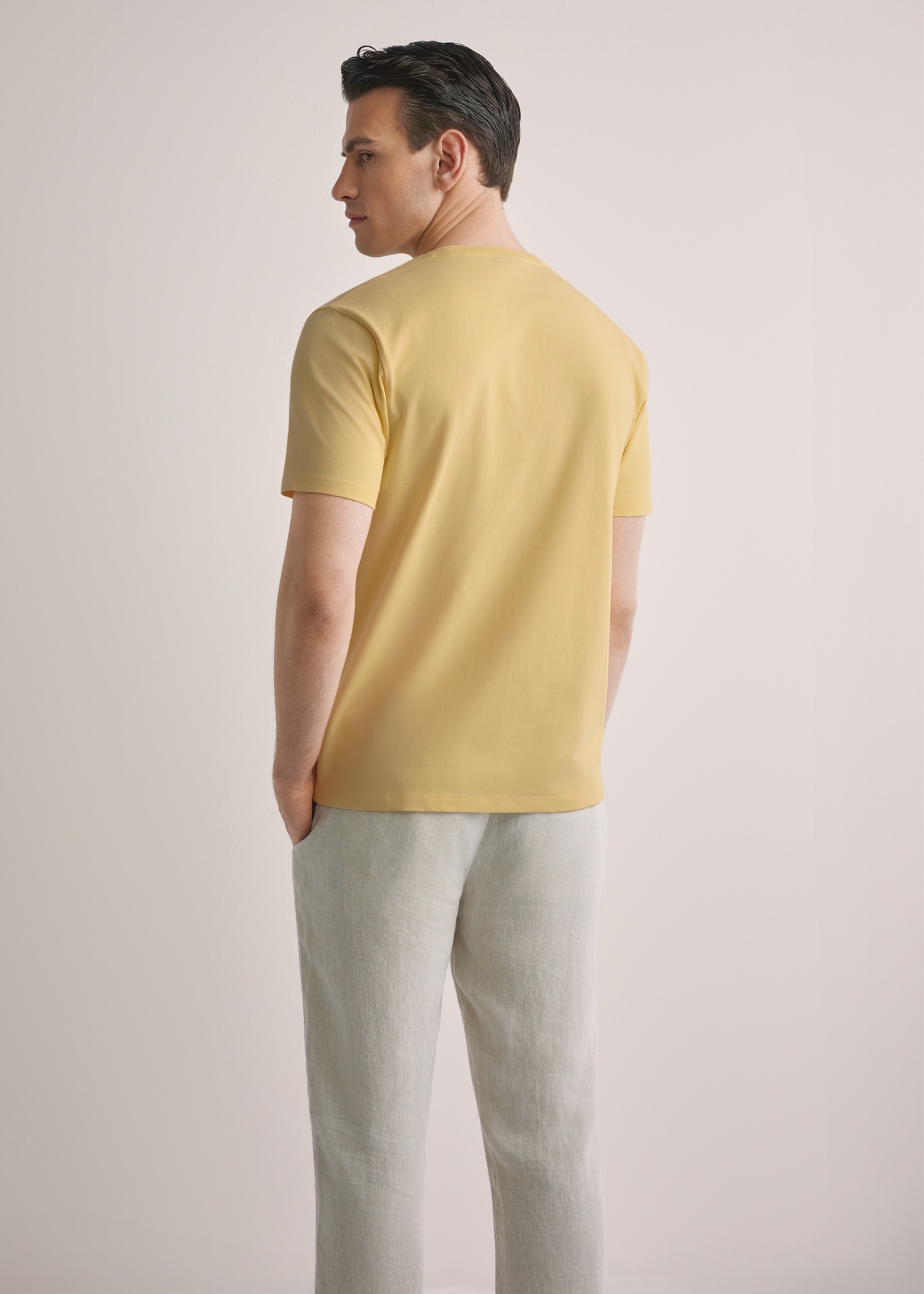 Żółty T-shirt męski TSHMT-0120-2B(W26), widok produktu z tyłu na modelu. Widoczna połowa sylwetki.