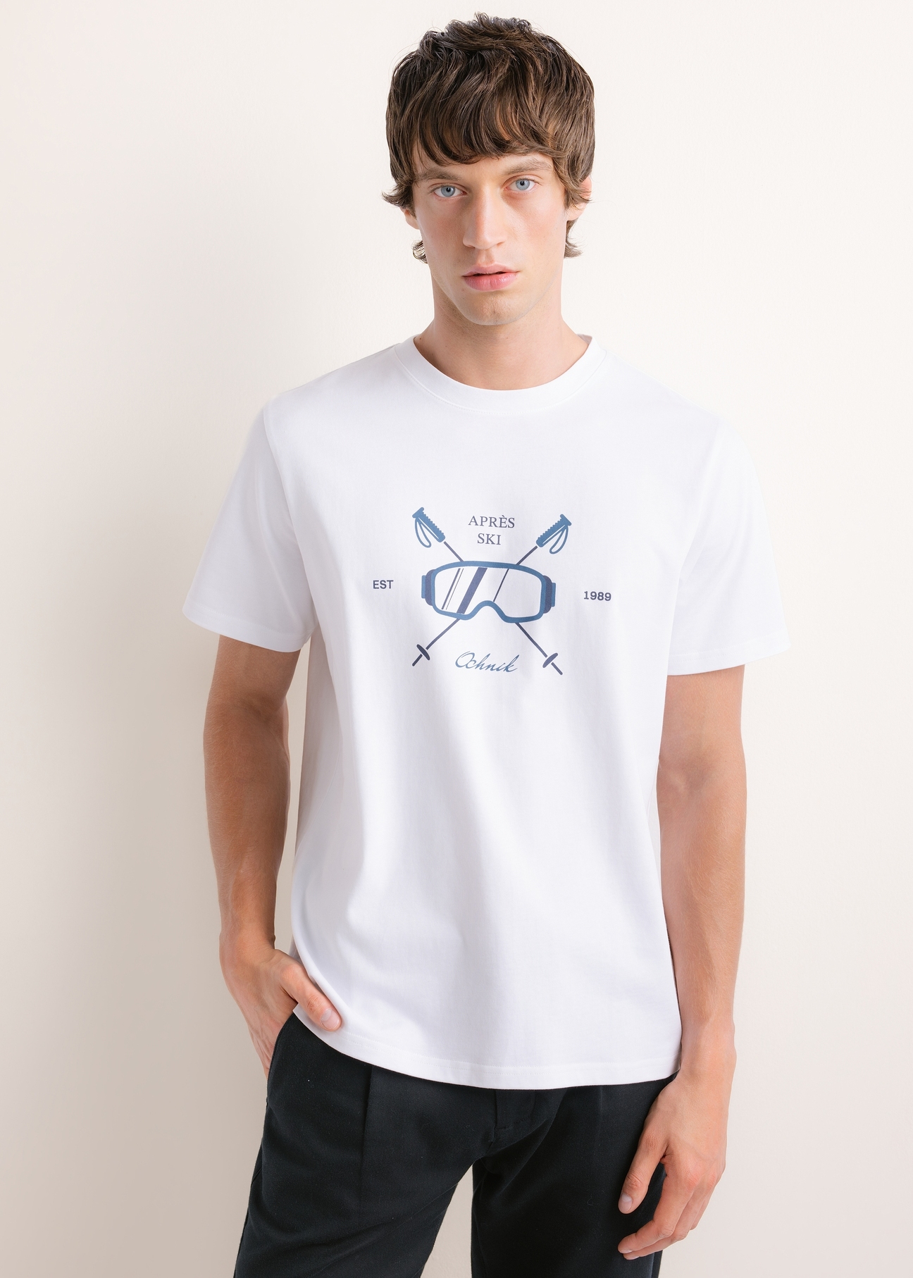 Biały T-shirt męski z nadrukiem TSHMT-0160-0A(Z26), widok produktu z przodu na modelu. Widoczna połowa sylwetki.