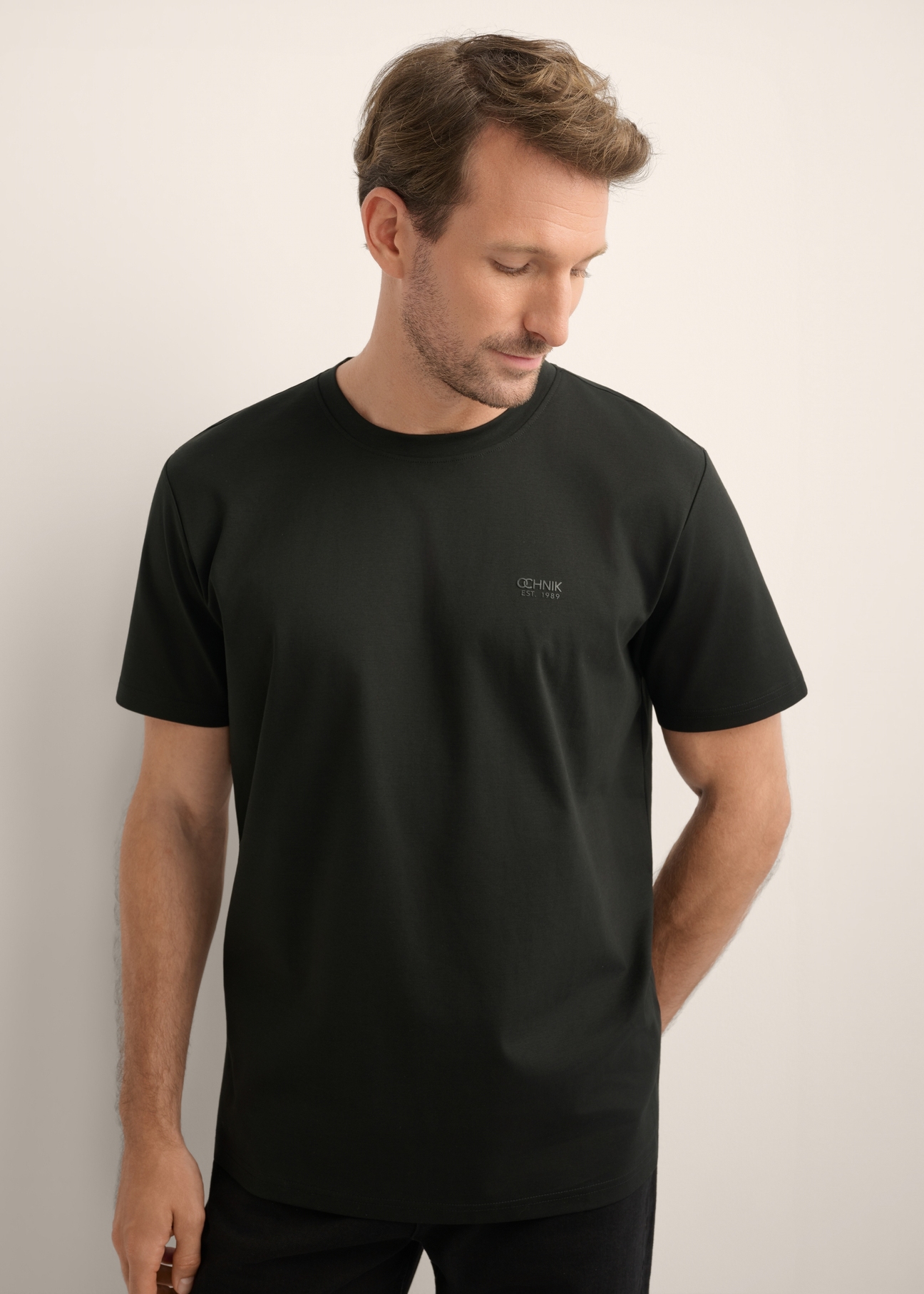 Czarny t-shirt męski z bawełny merceryzowanej TSHMT-0156-99(Z26), widok produktu z przodu na modelu. Widoczna połowa sylwetki.