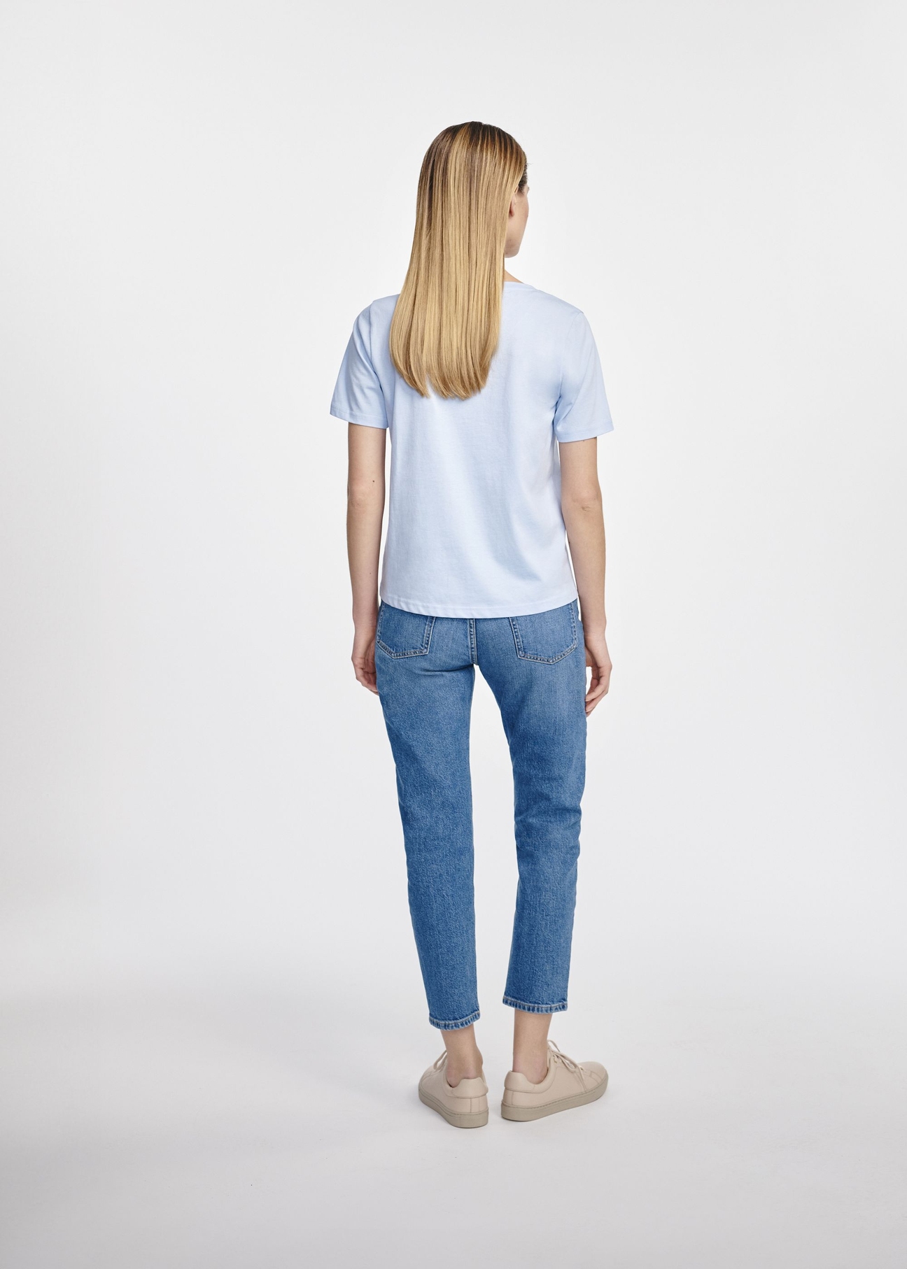 Błękitny t-shirt damski basic TSHDT-0120-60(W25), zdjęcie tyłu na modelce na białym tle. Widoczna cała sylwetka.