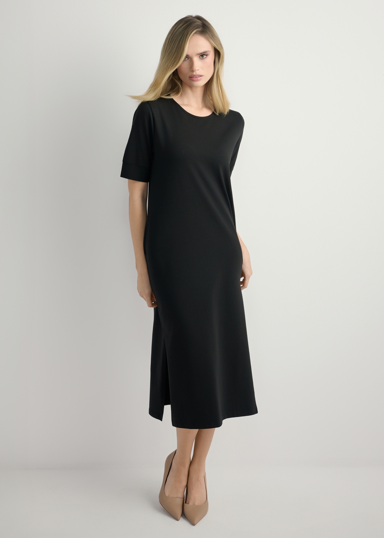 Czarna bawełniana sukienka midi SUKDT-0256-99(W26) - widok produktu z przodu, na modelce, na jasnym tle. Widoczna cała sylwetka. 