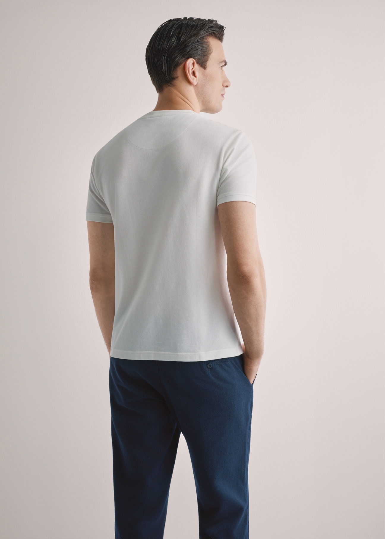 Kremowy bawełniany t-shirt męski TSHMT-0136-0B(W26), widok produktu z tyłu na modelu. Widoczna połowa sylwetki.