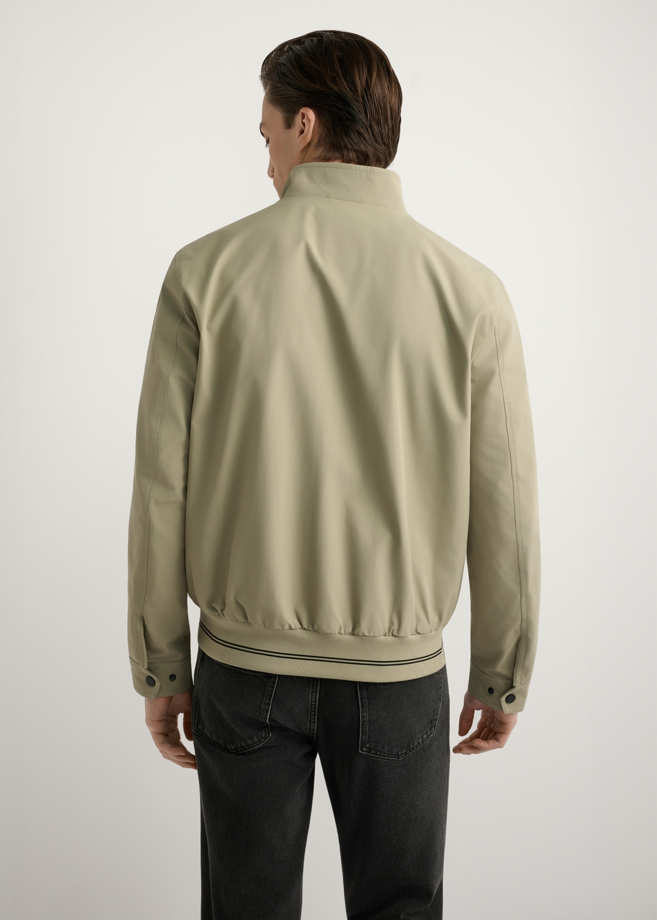 Kurtka męska przejściowa w kolorze khaki KURMT-0418-1B(W26), widok produktu z tyłu na modelu. Widoczna połowa sylwetki.