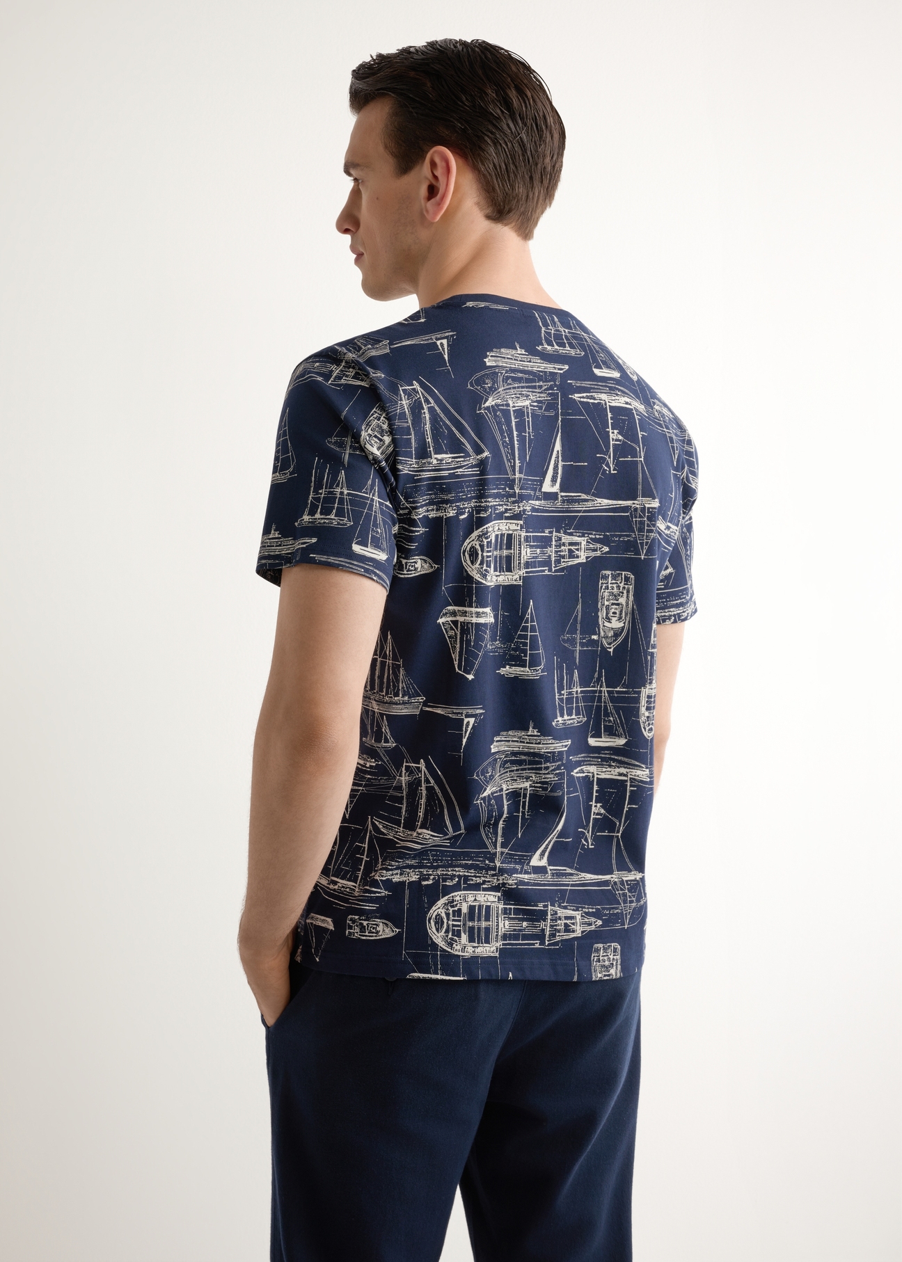 Granatowy t-shirt męski z grafiką TSHMT-0148-7E(W26), widok produktu z tyłu na modelu. Widoczna połowa sylwetki.