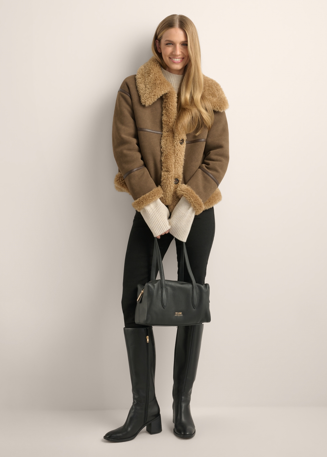 Skórzana torebka damska w kolorze czarnym TORES-1431-9I(Z26), widok produktu od przodu na modelce. Widoczna cała sylwetka.
