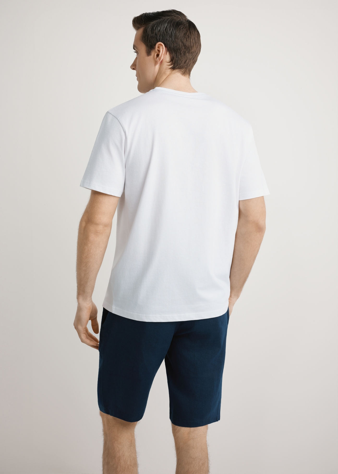  Biały T-shirt męski z nadrukiem TSHMT-0145-0A(W26),  widok produktu z tyłu na modelu. Widoczna połowa sylwetki.