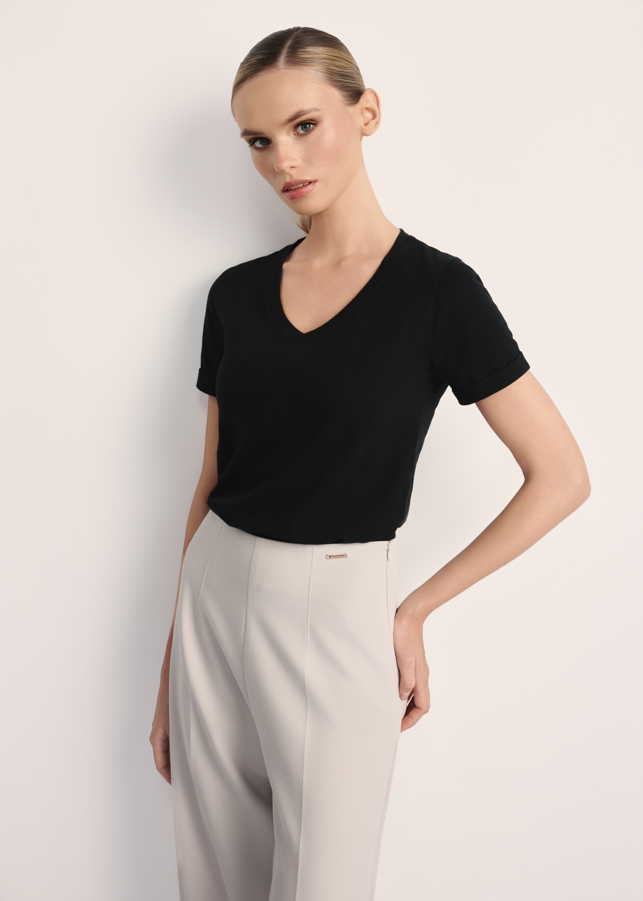 Czarny T-shirt damski w serek TSHDT-0118A-99(Z25), widok produktu z przodu na modelce. Widoczna połowa sylwetki.