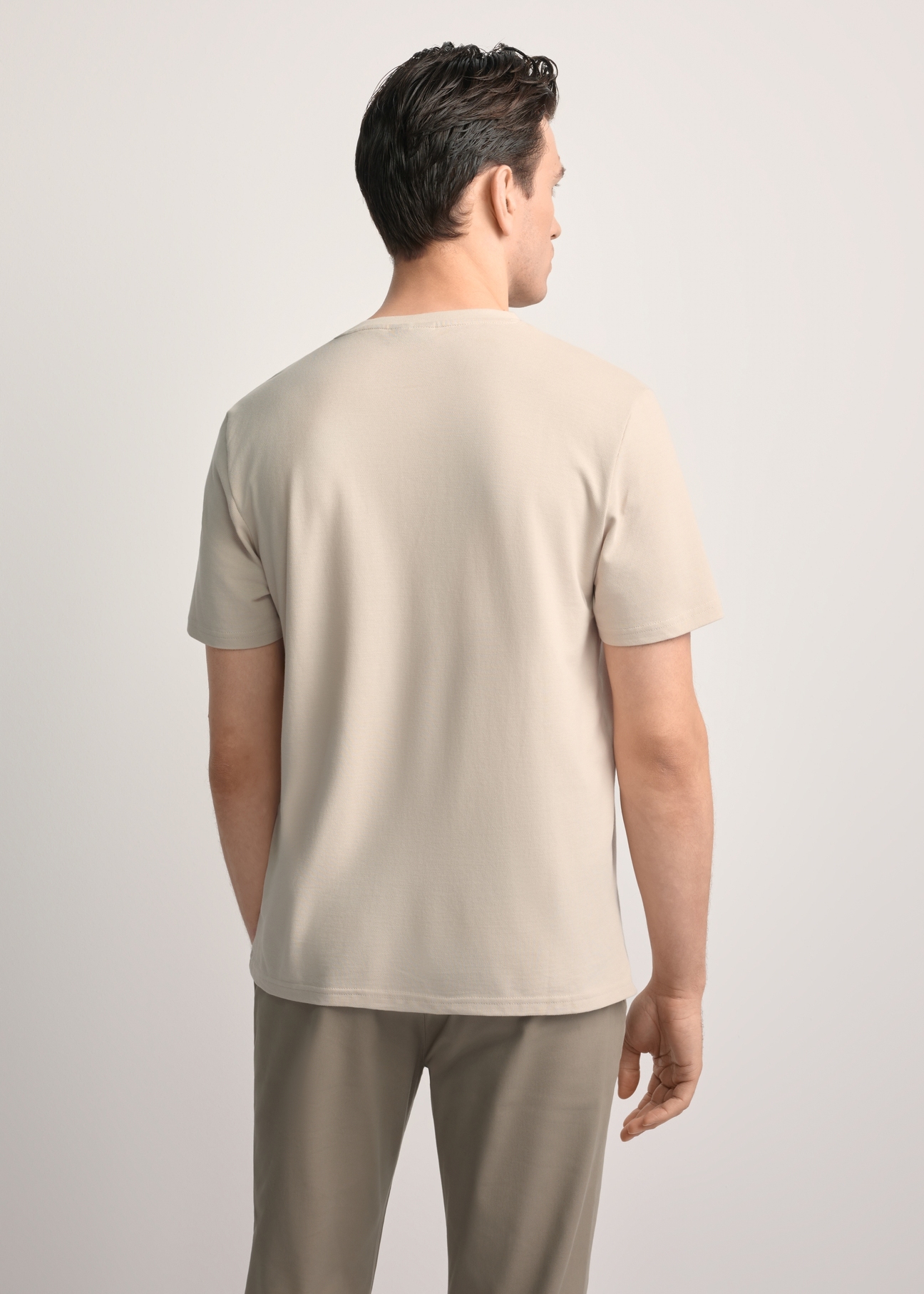Beżowy bawełniany t-shirt męski TSHMT-0129-80(Z25) - widok produktu z tyłu, na modelu, na białym tle. Widoczna sylwetka do kolan.