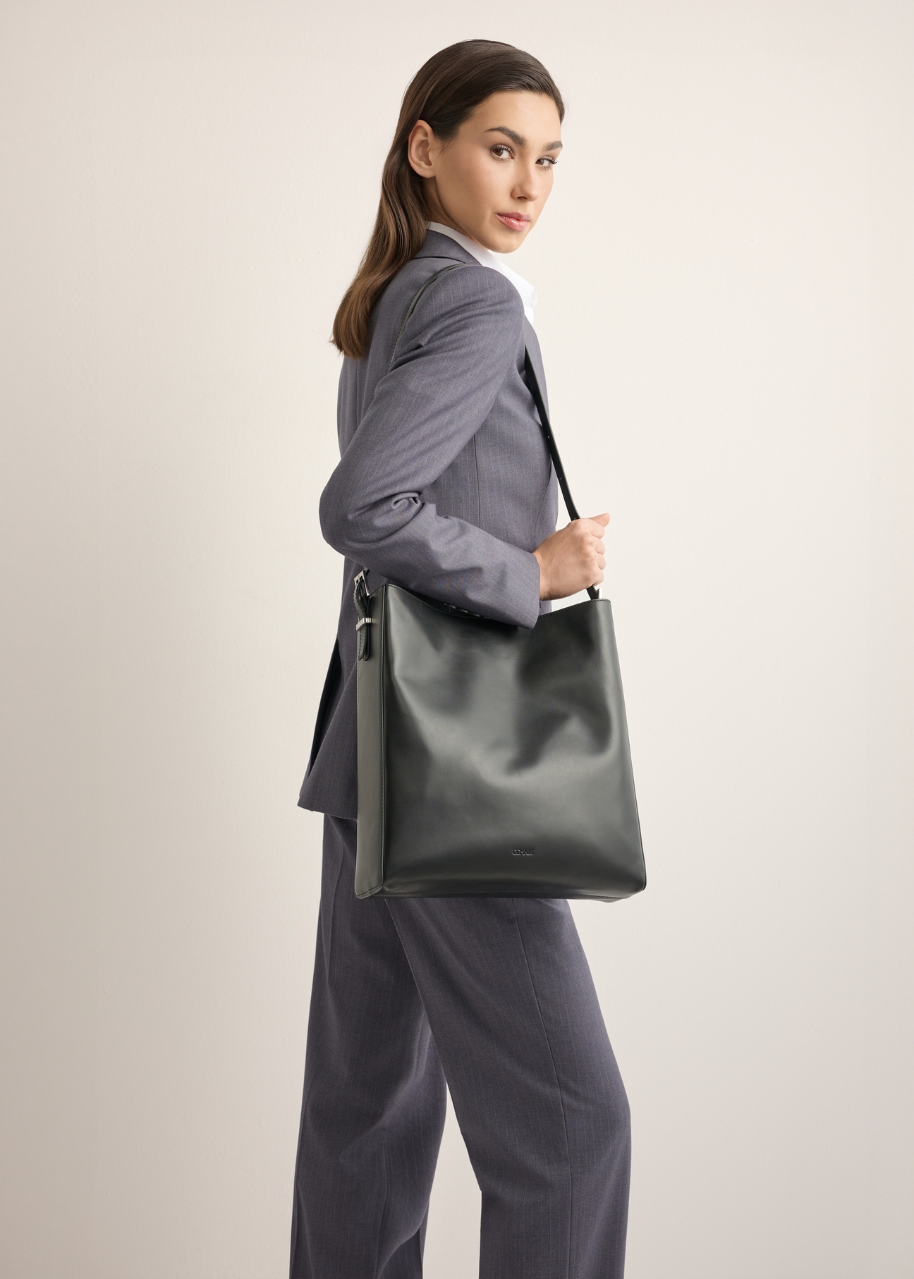 Czarna skórzana torebka shopper TORES-1436-99(Z26), widok produktu na ramieniu modelki. Widoczna połowa sylwetki.
