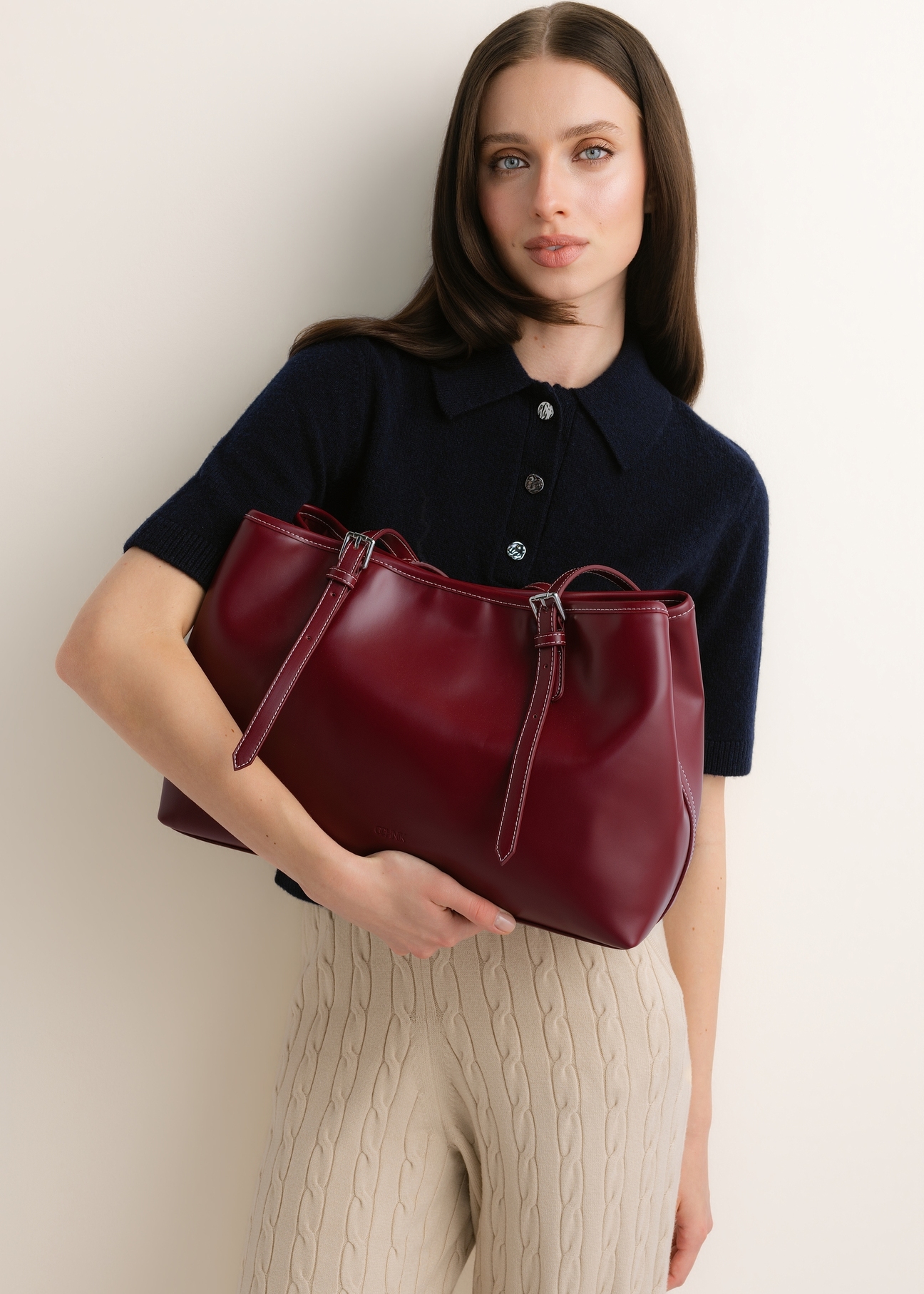 Bordowa duża torebka shopper TOREC-1381-4C(Z26), widok produktu w dłoniach modelki na jasnym tle.