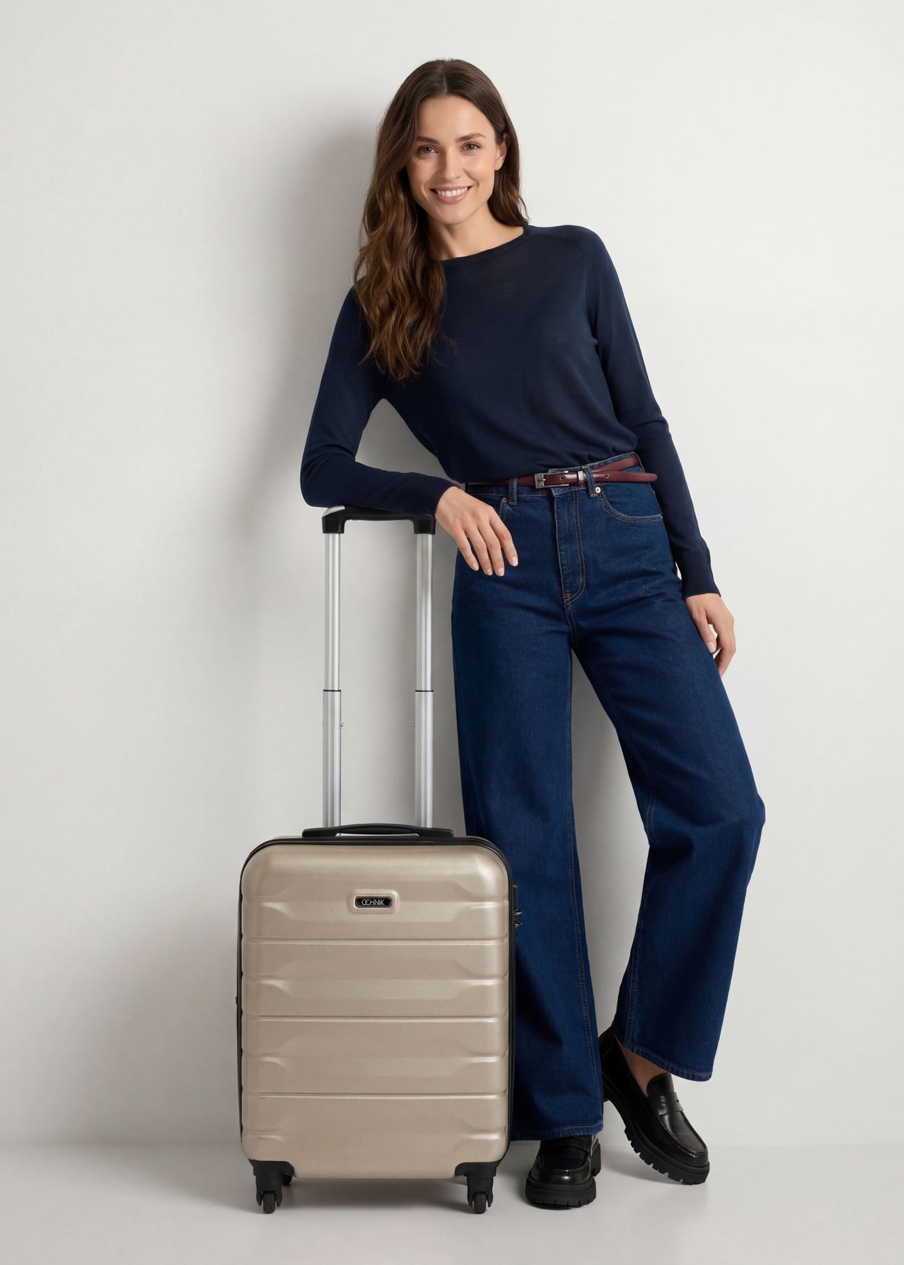 Walizka mała na kółkach WALAB-0067-0X-19(W26), widok produktu od przodu przy modelce, widoczna cała sylwetka.
