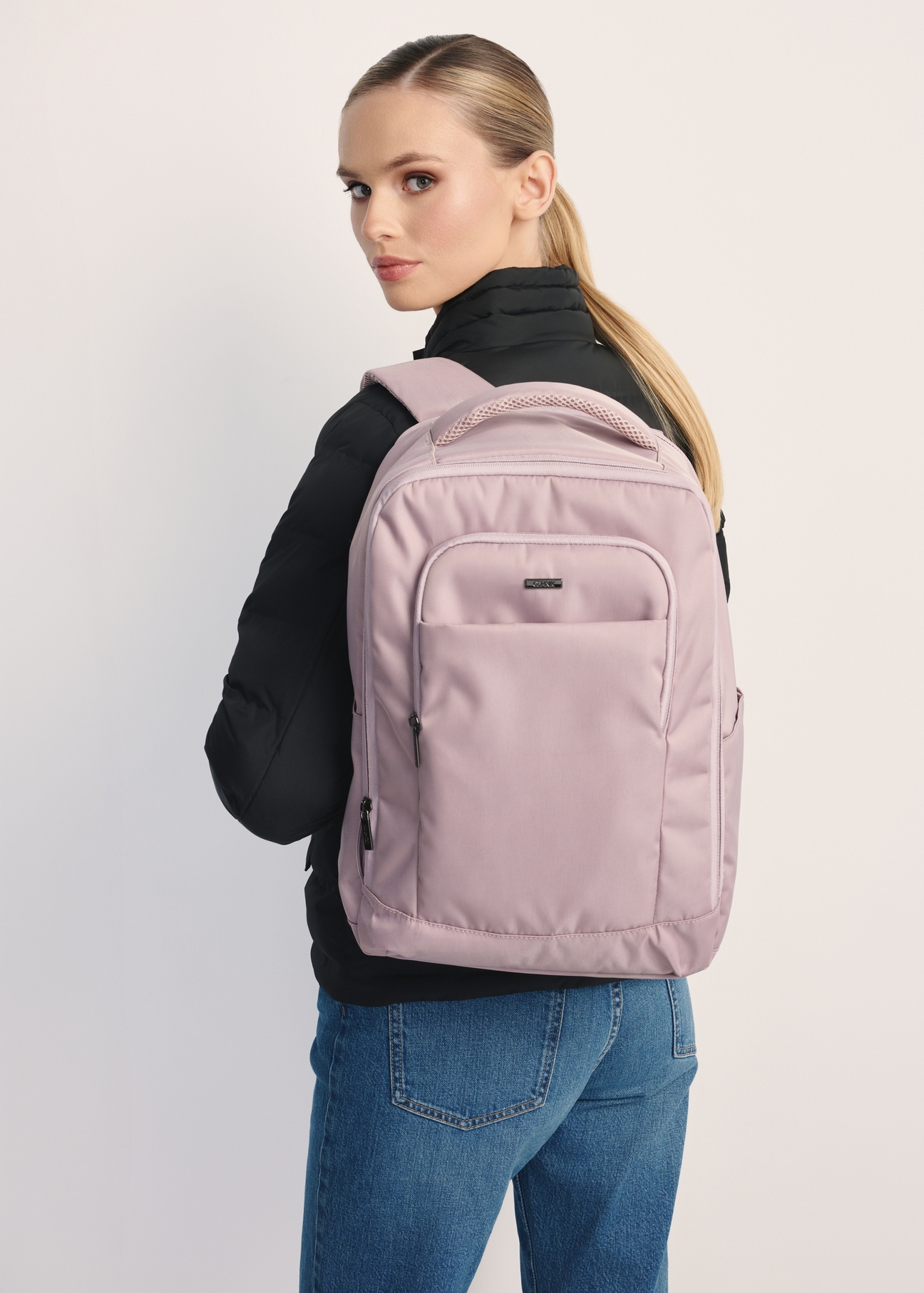 Różowy plecak PLCMN-0014A-31(Z25), widok produktu przodem na modelce, widoczne pół sylwetki.