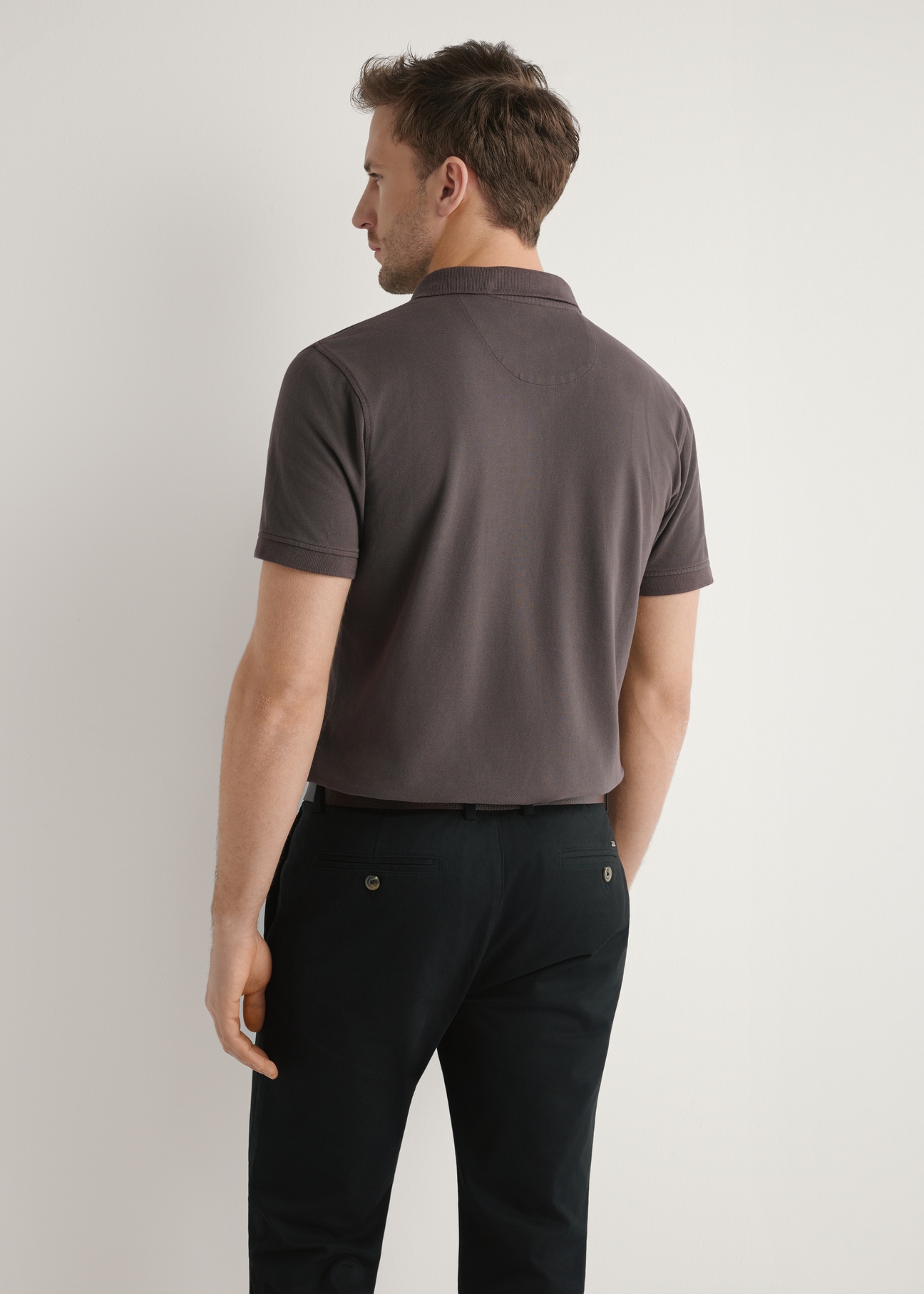 Męska koszulka polo w kolorze brązowym POLMT-0055A-1I(W26), widok produktu z tyłu na modelu. Widoczna połowa sylwetki.
