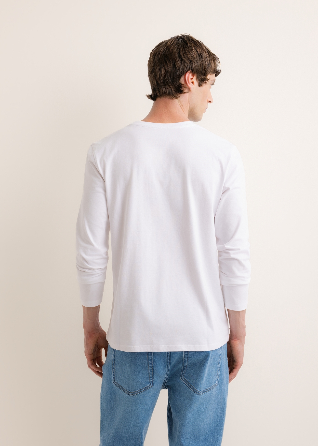 Biały bawełniany longsleeve męski LSLMT-0013-0A(Z26), widok produktu z tyłu na modelu. Widoczna połowa sylwetki.