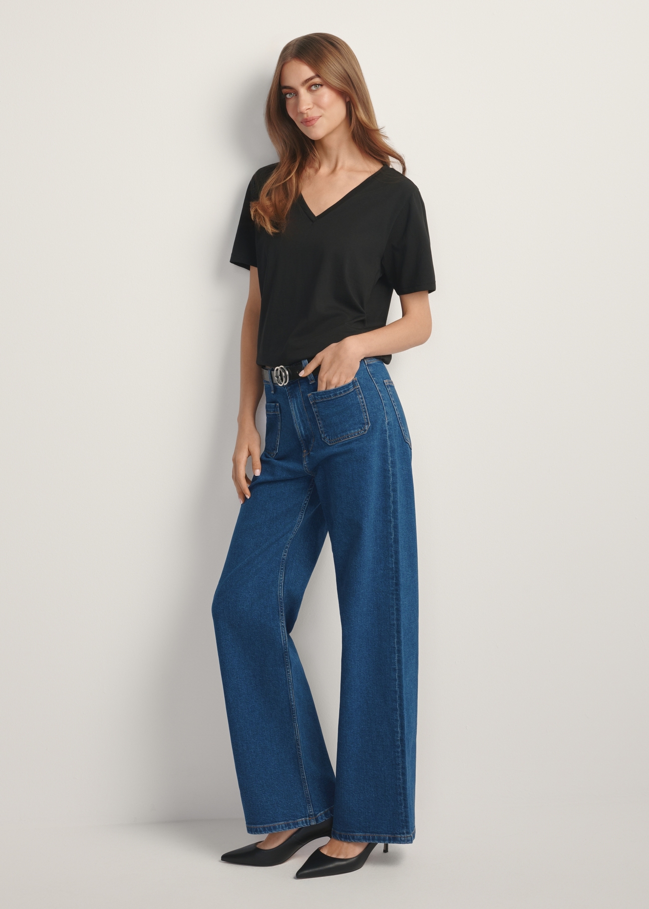 Niebieskie jeansowe spodnie damskie JEADT-0014-7H(W26), widok produktu z przodu na modelce. Widoczna cała sylwetka.