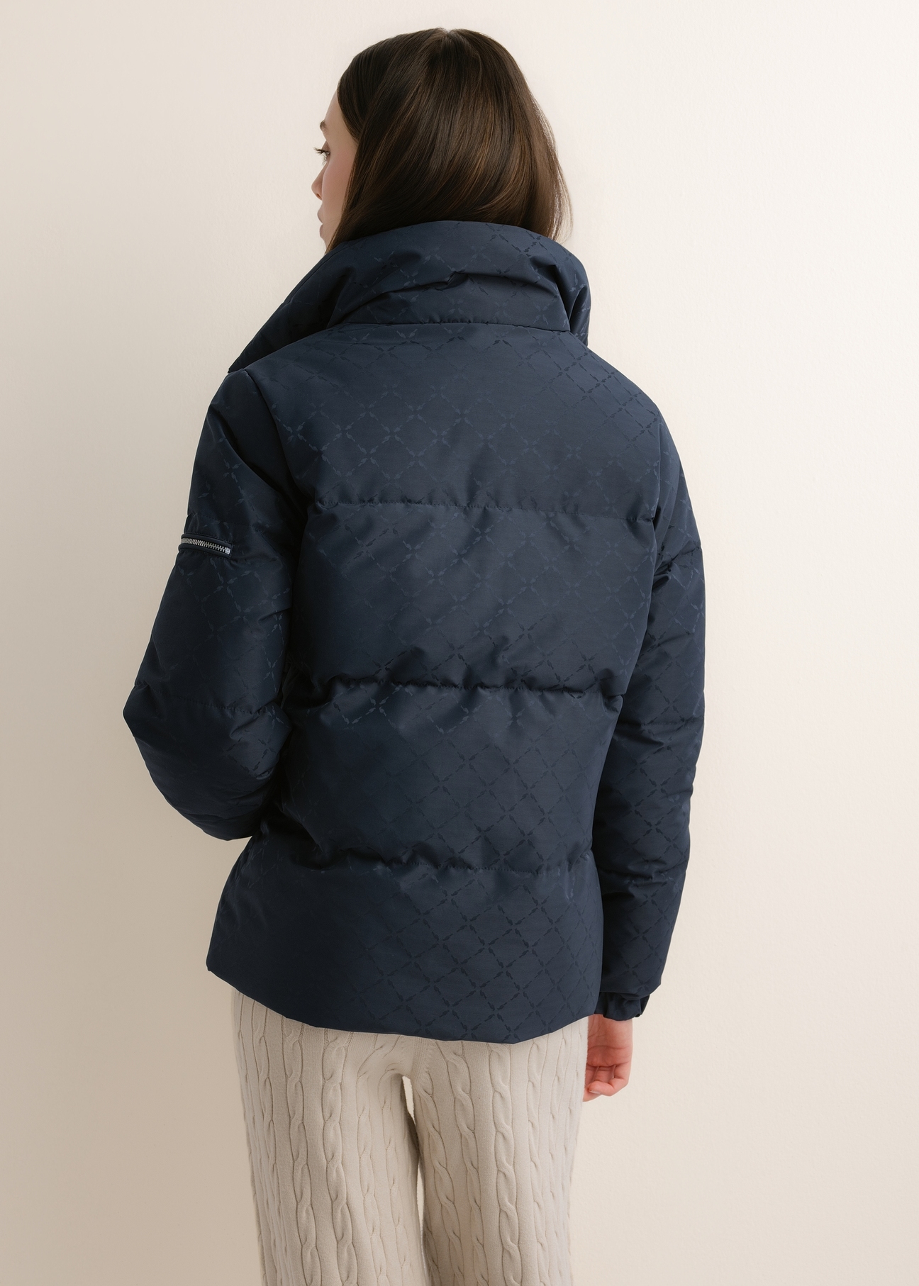 Granatowa kurtka damska w monogram ze stójką KURDT-0694-7E(Z26), widok produktu z tyłu na modelce. Widoczna połowa sylwetki.