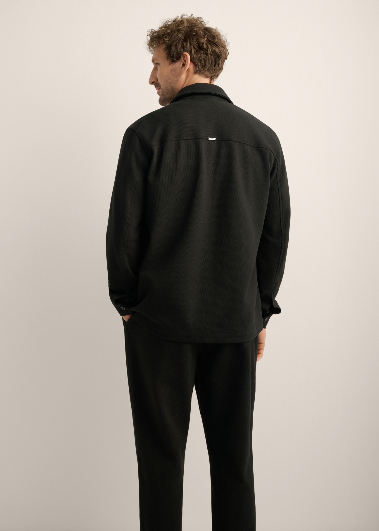 Męska koszula dzianinowa oversize KOSMT-0366-99(Z26). Widok produktu z tyłu na modelu. Widoczna połowa sylwetki. 