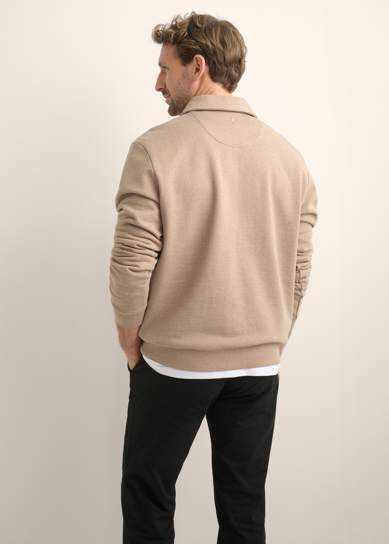 Beżowa bawełniana bluza męska BLZMT-0081-1D(Z26), widok produktu od tyłu na modelu. Widoczna połowa sylwetki.