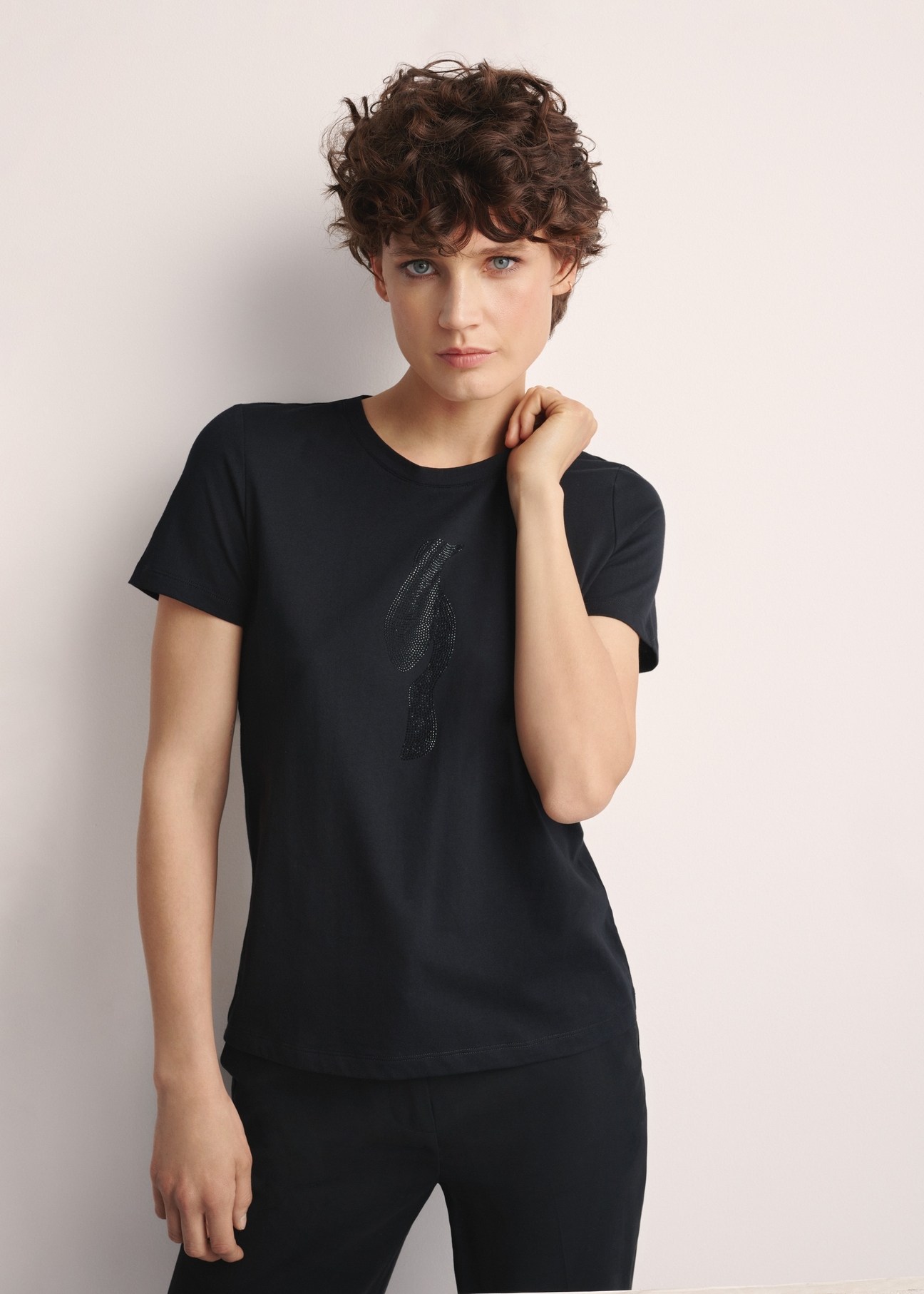 Czarny T-shirt damski z logo TSHDT-0148-99(Z25), widok produktu z przodu na modelce. Widoczna połowa sylwetki.
