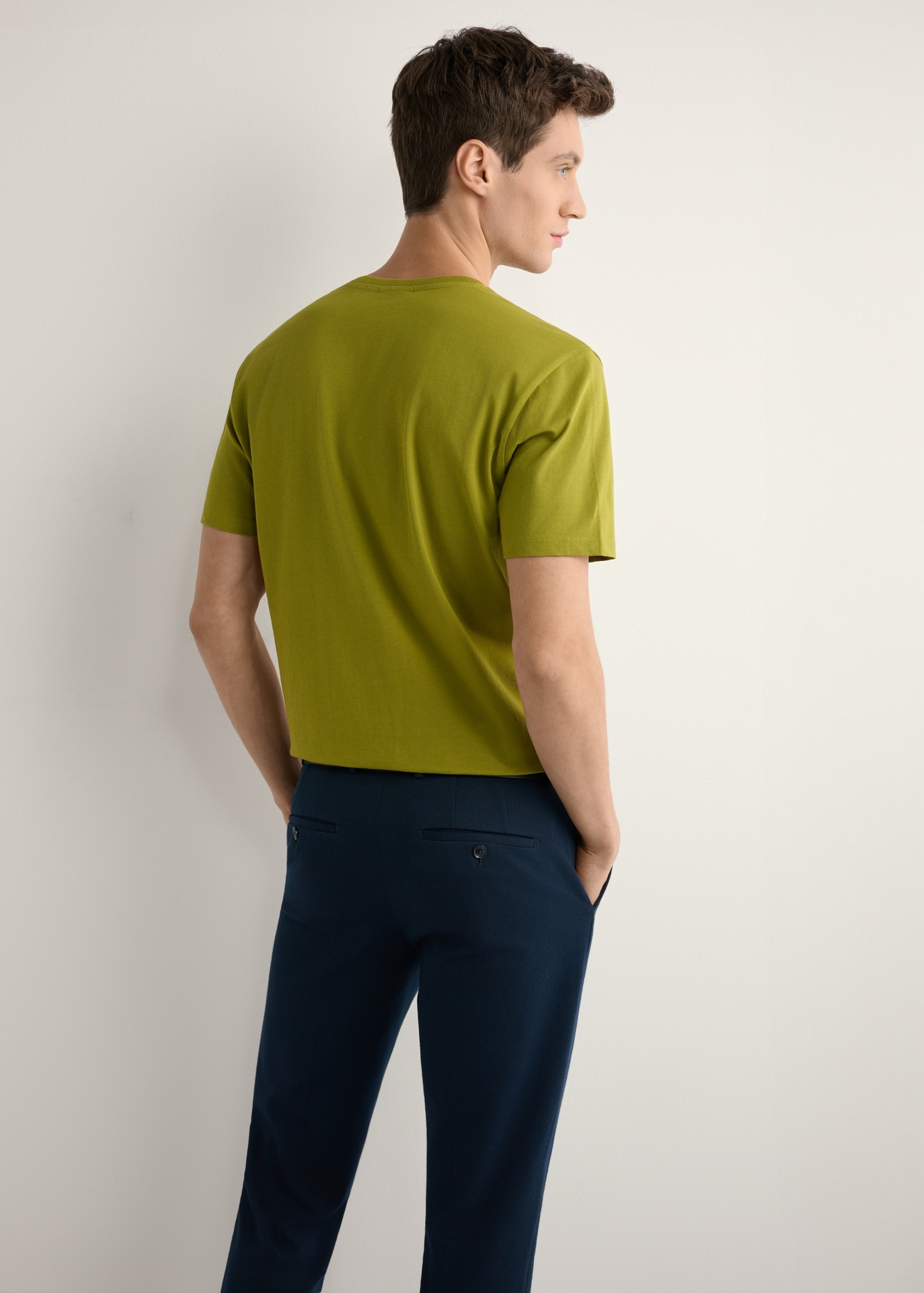 Oliwkowy T-shirt męski TSHMT-0120-8E(W26), widok produktu z tyłu na modelu. Widoczna połowa sylwetki.