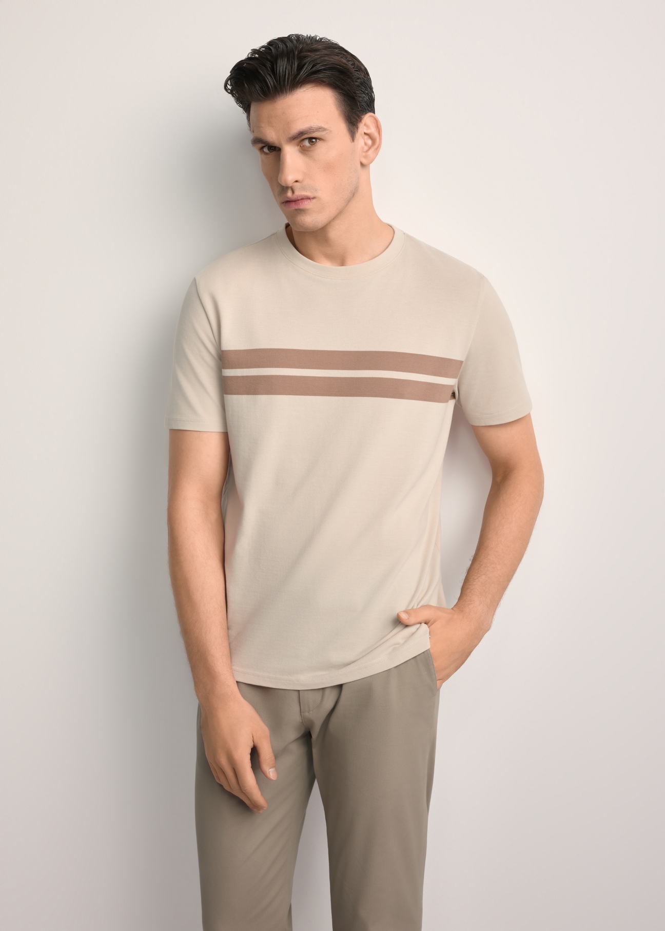Beżowy bawełniany t-shirt męski TSHMT-0129-80(Z25) - widok produktu z przodu, na modelu, na białym tle. Widoczna sylwetka do kolan. 