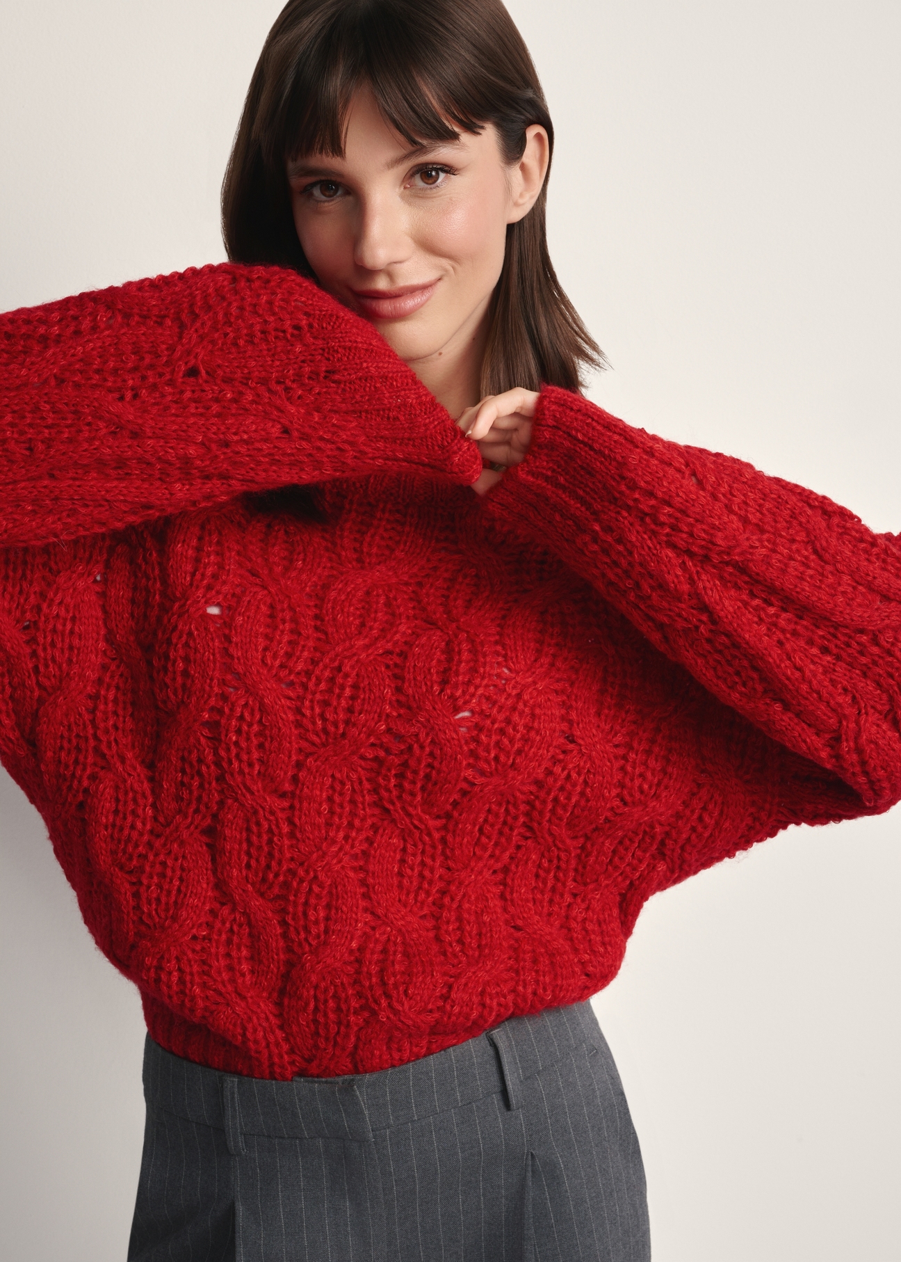 Czerwony sweter damski SWEDT-0236-42(Z25), widok produktu z przodu na modelce. Widoczna połowa sylwetki.