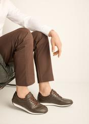 Brązowe skórzane buty sportowe męskie BUTYM-0566-1I(Z26) - widok produktu z z boku, na stopach modela, na jasnym tle. 
