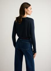 Cienki granatowy sweter damski SWEDT-0257-7E(W26), widok produktu od tyłu na modelce, widoczna połowa sylwetki.