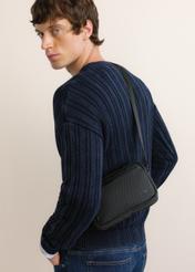 Czarna torba męska na ramię TORMN-0433-99(Z26), widok produktu skosem na modelu. Widoczna połowa sylwetki.