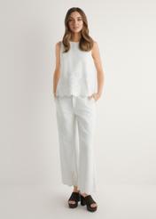 Białe spodnie damskie wide leg SPODT-0122-0B(W26), widok produktu z przodu na modelce. Widoczna cała sylwetka.