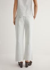 Białe spodnie damskie wide leg SPODT-0122-0B(W26), widok produktu z tyłu na modelce. Widoczna połowa sylwetki.