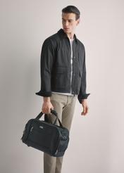 Czarna torba męska z nylonu TORMN-0420-99(W26), widok produktu w dłoni modela, na jasnym tle. Widoczna połowa sylwetki.