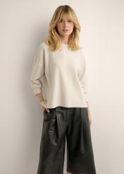 Jasnobeżowy sweter damski SWEDT-0263-1A(Z26), widok produktu z przodu na modelce. Widoczna połowa sylwetki.