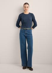 Damskie jeansy wide leg w kolorze ciemnogranatowym JEADT-0019-7D(Z26), widok produktu z przodu na modelce. Widoczna cała sylwetka.