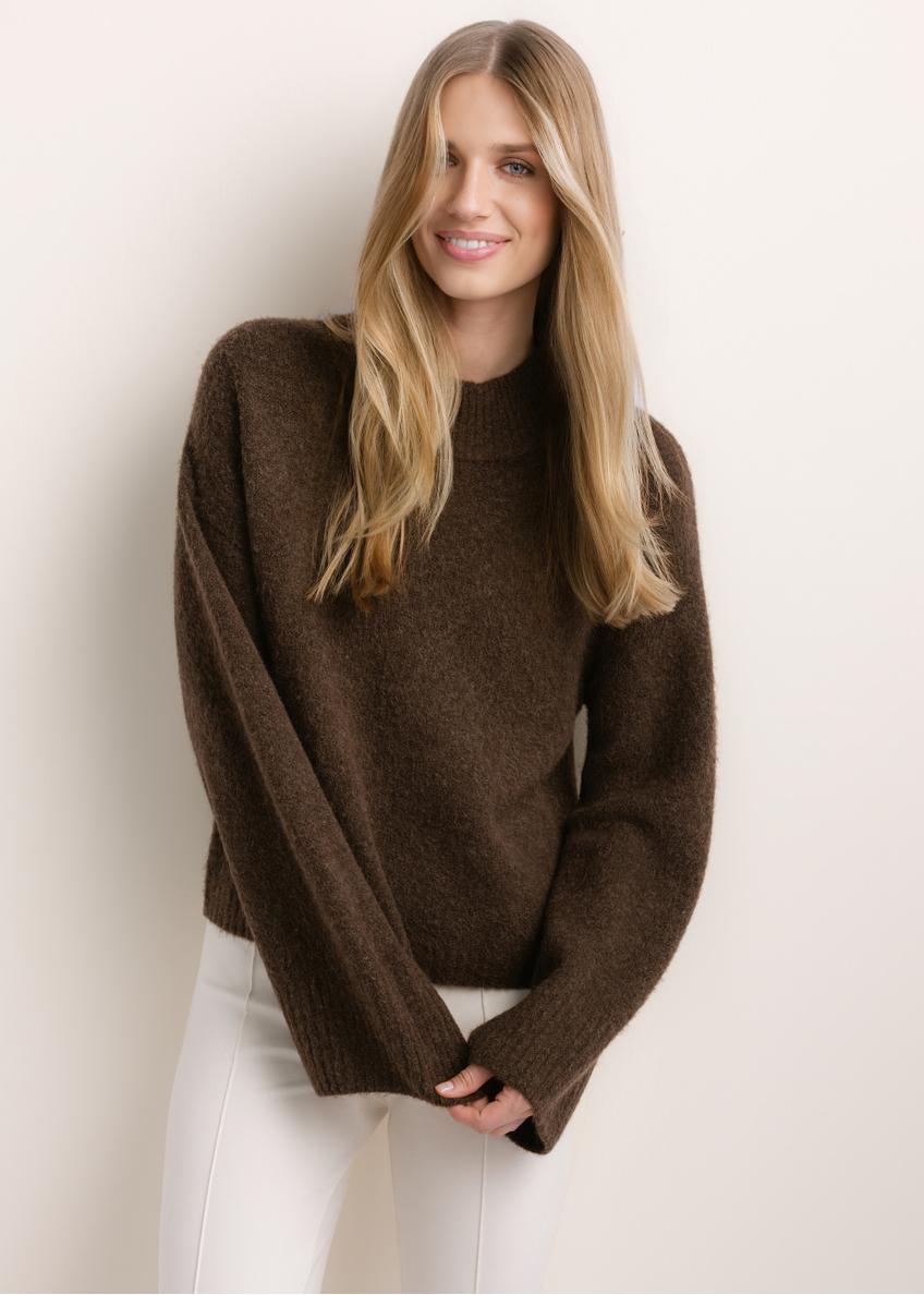 Ciemnobrązowy sweter damski oversize SWEDT-0270-1I(Z26), widok produktu od przodu na modelce. Widoczna połowa sylwetki.