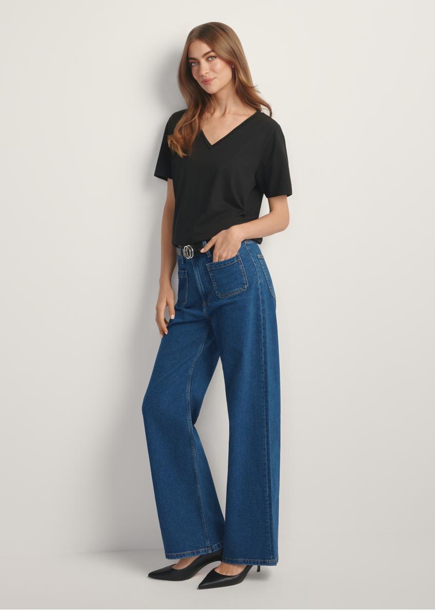 Niebieskie jeansowe spodnie damskie JEADT-0014-7H(W26), widok produktu z przodu na modelce. Widoczna cała sylwetka.